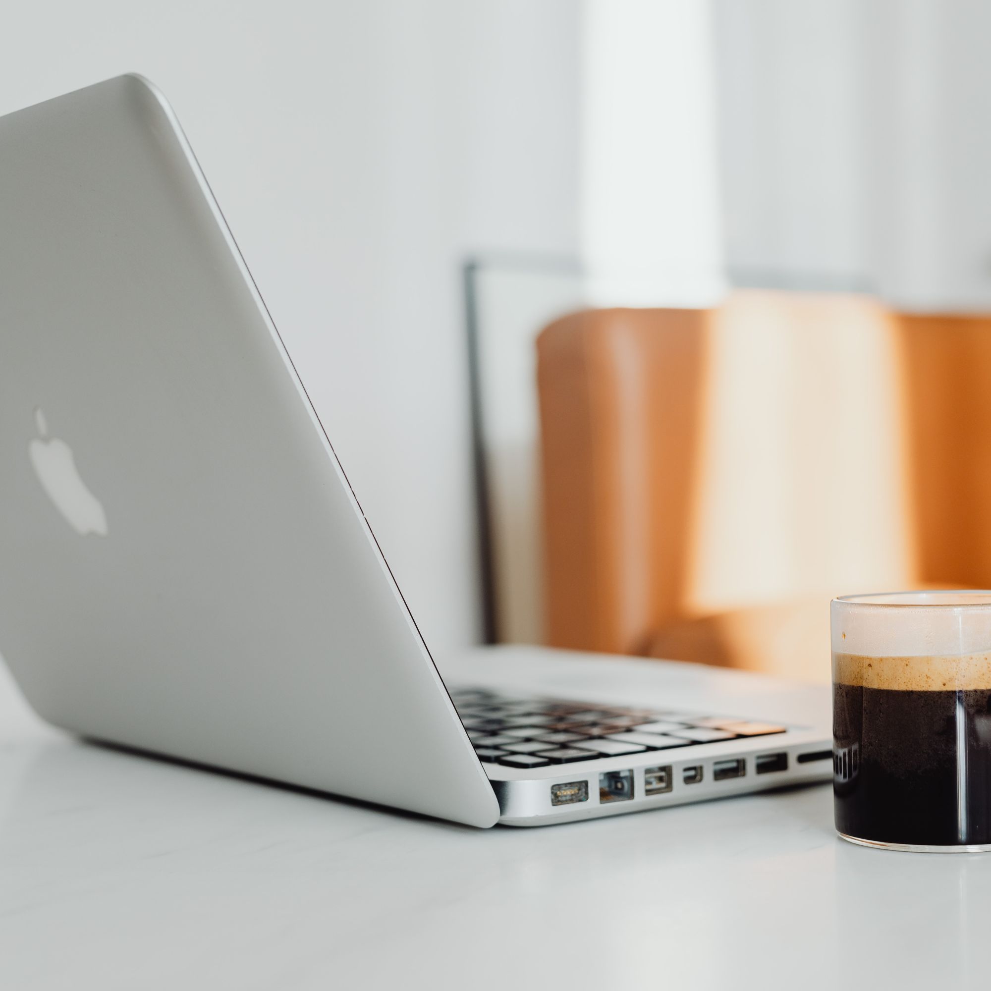 Mesa de trabalho com notebook, café e materiais de planejamento de comunicação.